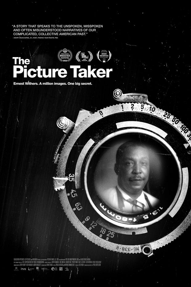 Film poster for "The Picture Taker" with man in camera lens in black and white.