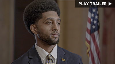 Trailer for documentary "The Body Politic" directed by Gabriel Francis Paz Goodenough. Closeup of young black man with American flag in background. https://vimeo.com/1077412553