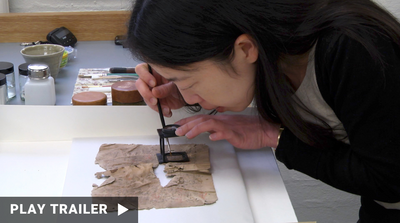 Trailer for documentary "FROM CAIRO TO THE CLOUD” directed by Michelle Paymar. A woman looking closely at a document. https://vimeo.com/1004945923