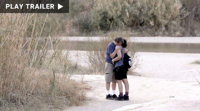 Trailer for documentary "Facing the Wind" directed by Deirdre Fishel. Man hugging woman on beach. https://vimeo.com/1045865573