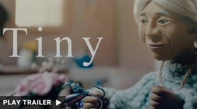 Trailer for "TINY" directed by Ritchie Hemphill & Ryan Haché. An old woman doll smiles. https://vimeo.com/945978259