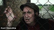 "GIMPEL THE FOOL RETURNS TO POLAND" directed by Howard Rypp. Close-up of a man standing behind a fence looking anxiously ahead.