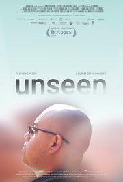 Film Poster for "UNSEEN". A bald young man wearing glasses appears in-focus, admist hazy figures. He looks up to the endless bright sky, his expression prensive. The film's billing black, logos, festival laurels adorn the sky as the skyline meets the young man's head in the middle of the poster. The film's title appears: unseen.